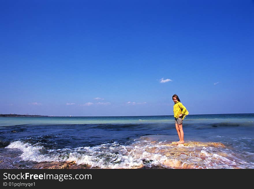 Little, cute girl looking to rocks and sea. Little, cute girl looking to rocks and sea