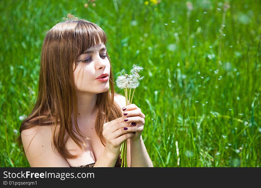 Young Girl Blowing On Dandelion