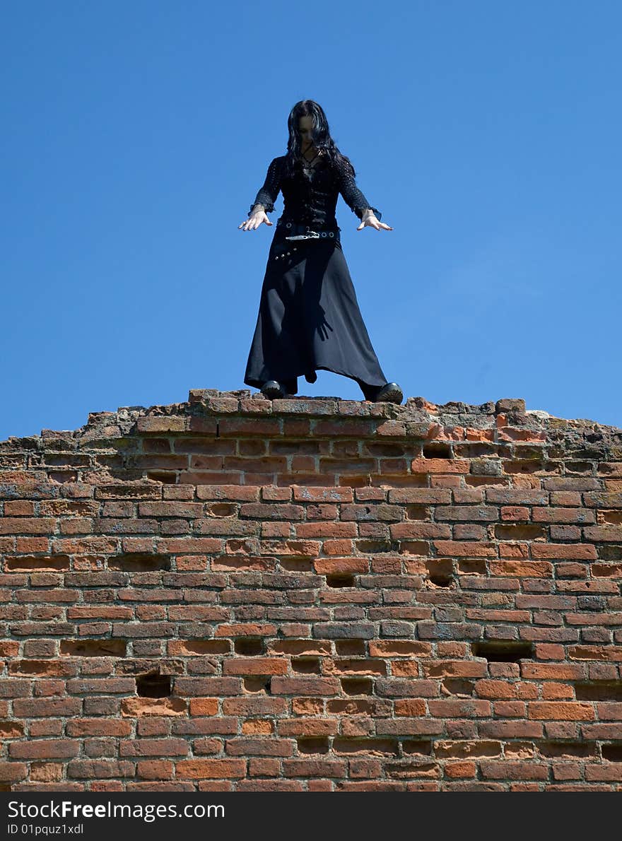 Young gothic girl and ruins of castle