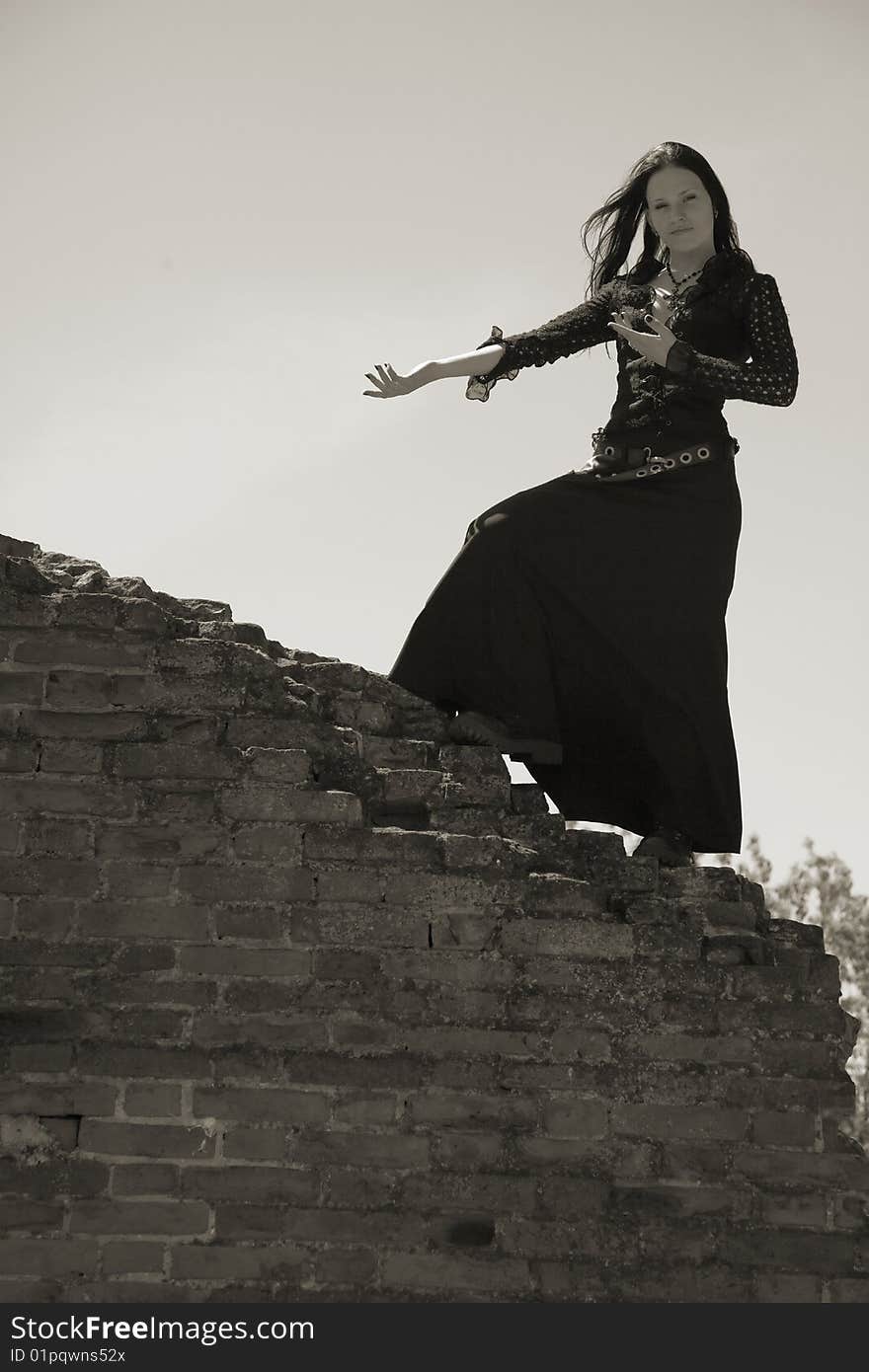 Young gothic girl and ruins of castle