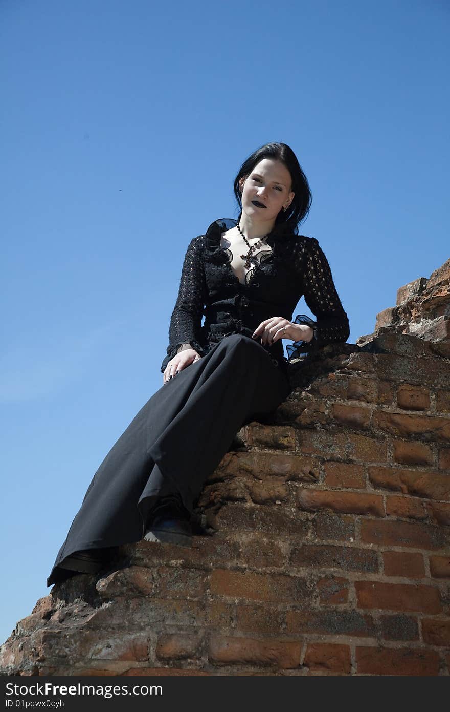 Young gothic girl and ruins of castle