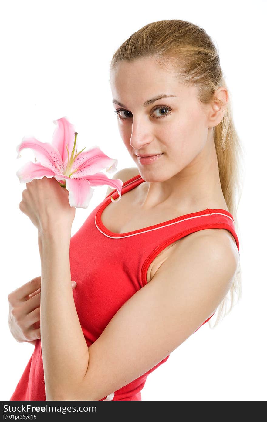 A nice blond girl in red posing with a pink lily near her face on a white background. A nice blond girl in red posing with a pink lily near her face on a white background