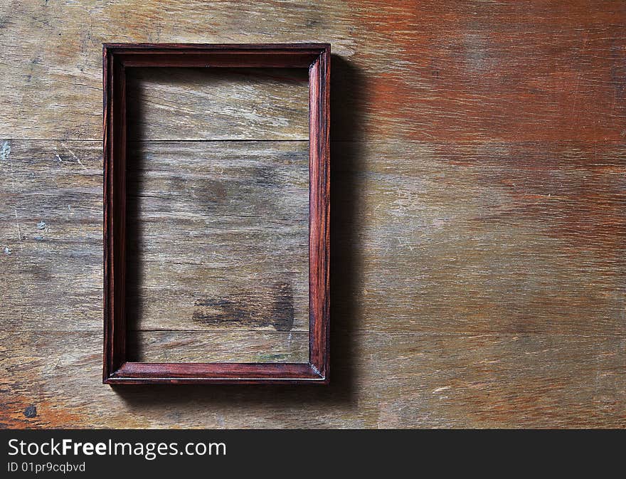 Empty frame on wooden background