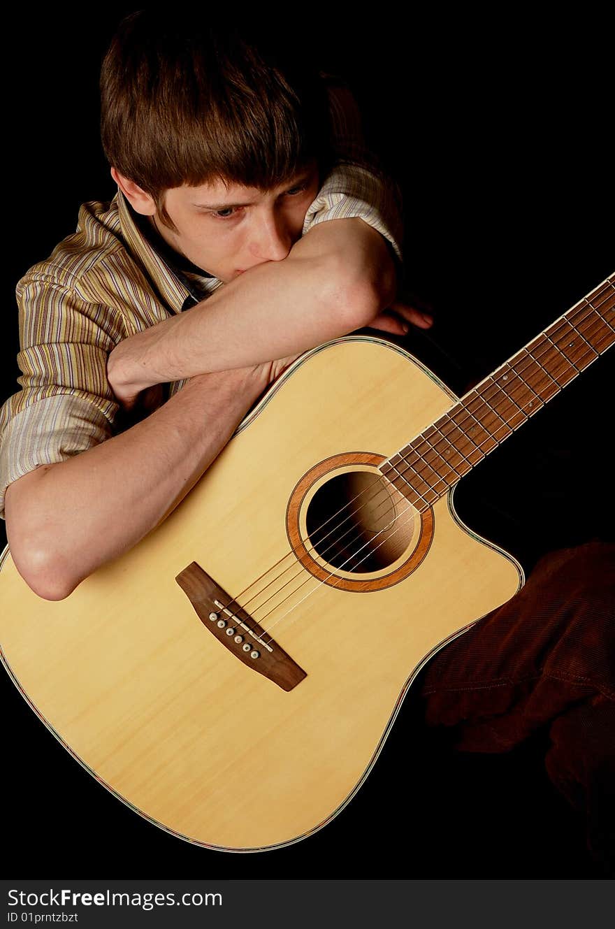 Young musician playing guitar isolated on black. Young musician playing guitar isolated on black