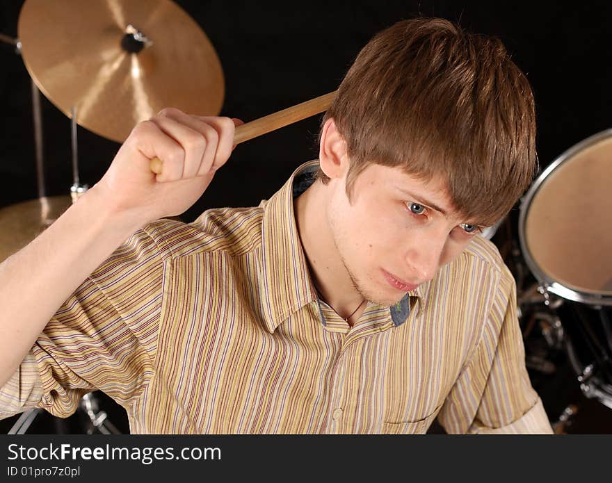 Young musician playing drums isolated on black. Young musician playing drums isolated on black.