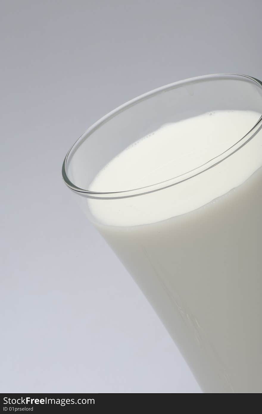 A glass of milk with ice on gray  background. A glass of milk with ice on gray  background