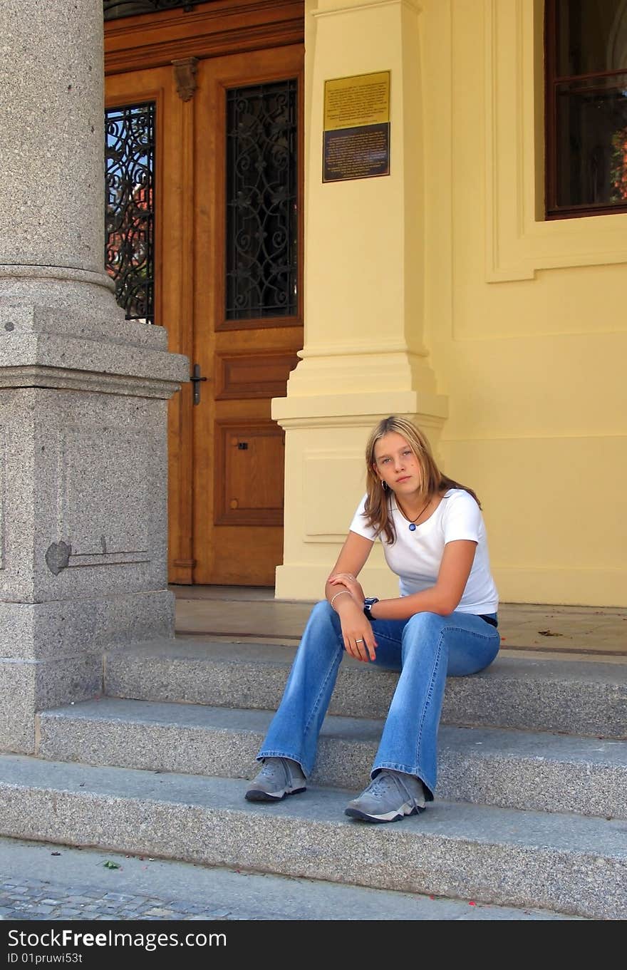 Teen girl sitting on the stairs.