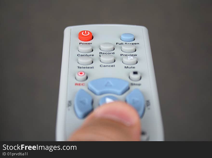 A hand holding a TV remote. A hand holding a TV remote