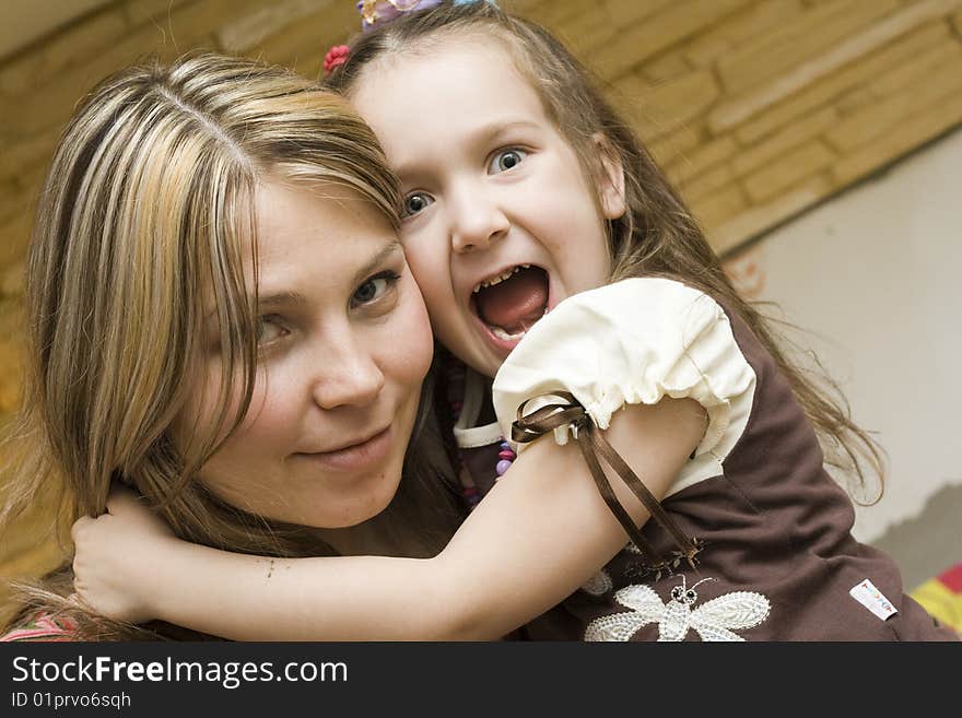 Cute girl sitting with beautiful mother at home. Cute girl sitting with beautiful mother at home