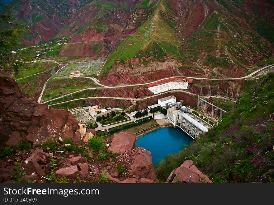 Water basin with blue water in red mountains The top view on Hydroelectric power station. Water basin with blue water in red mountains The top view on Hydroelectric power station.