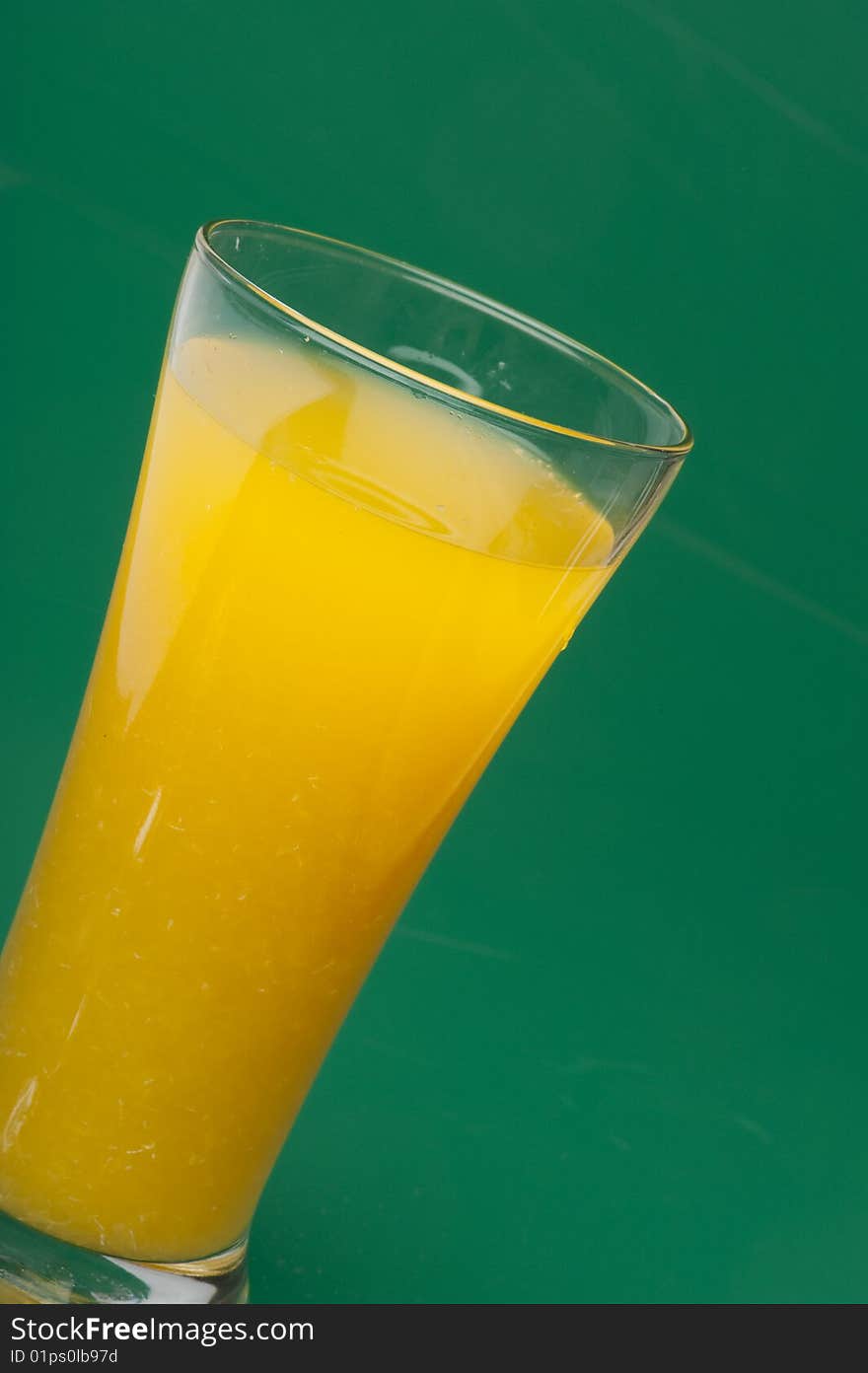 Glass of orange juice with ice cube