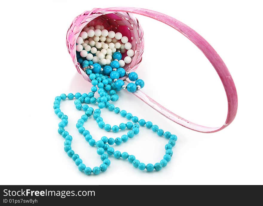 Colored Pearl Beads in Pink Wicker Basket Isolated on White Background