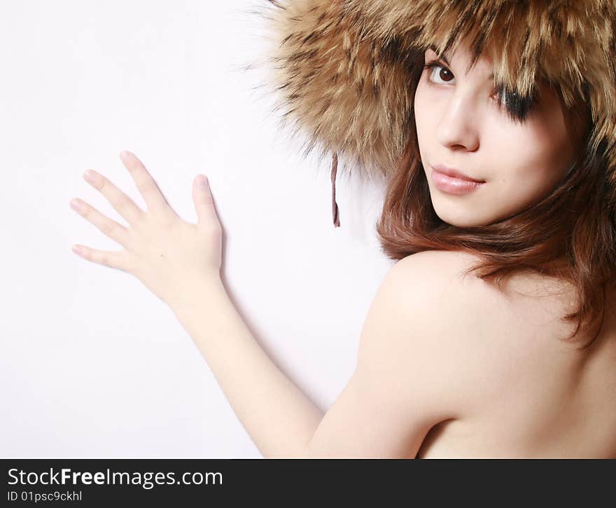 Portrait of the beautiful girl in a fur cap close up.