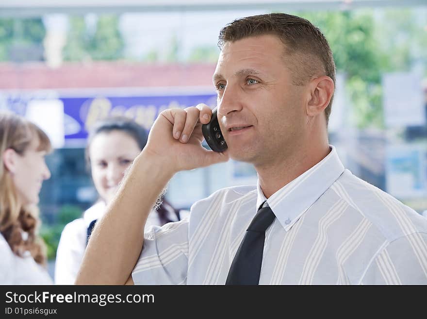 Portrait of young man  with phone  in business environment. Portrait of young man  with phone  in business environment