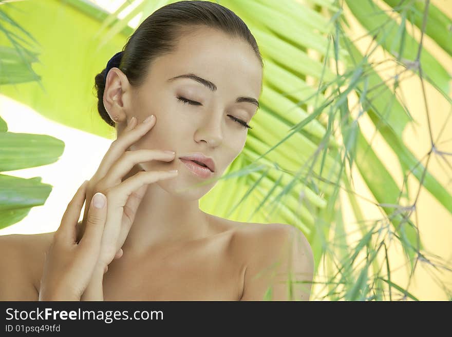 Portrait of young beautiful woman on green leafs back. Portrait of young beautiful woman on green leafs back