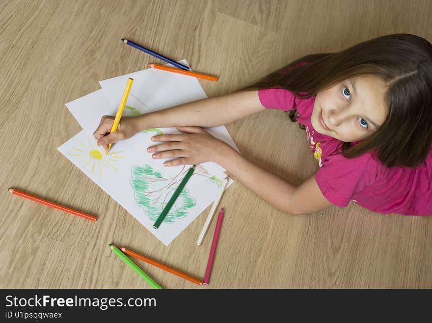 Young girl lying on the floor and drawing a picture. Young girl lying on the floor and drawing a picture