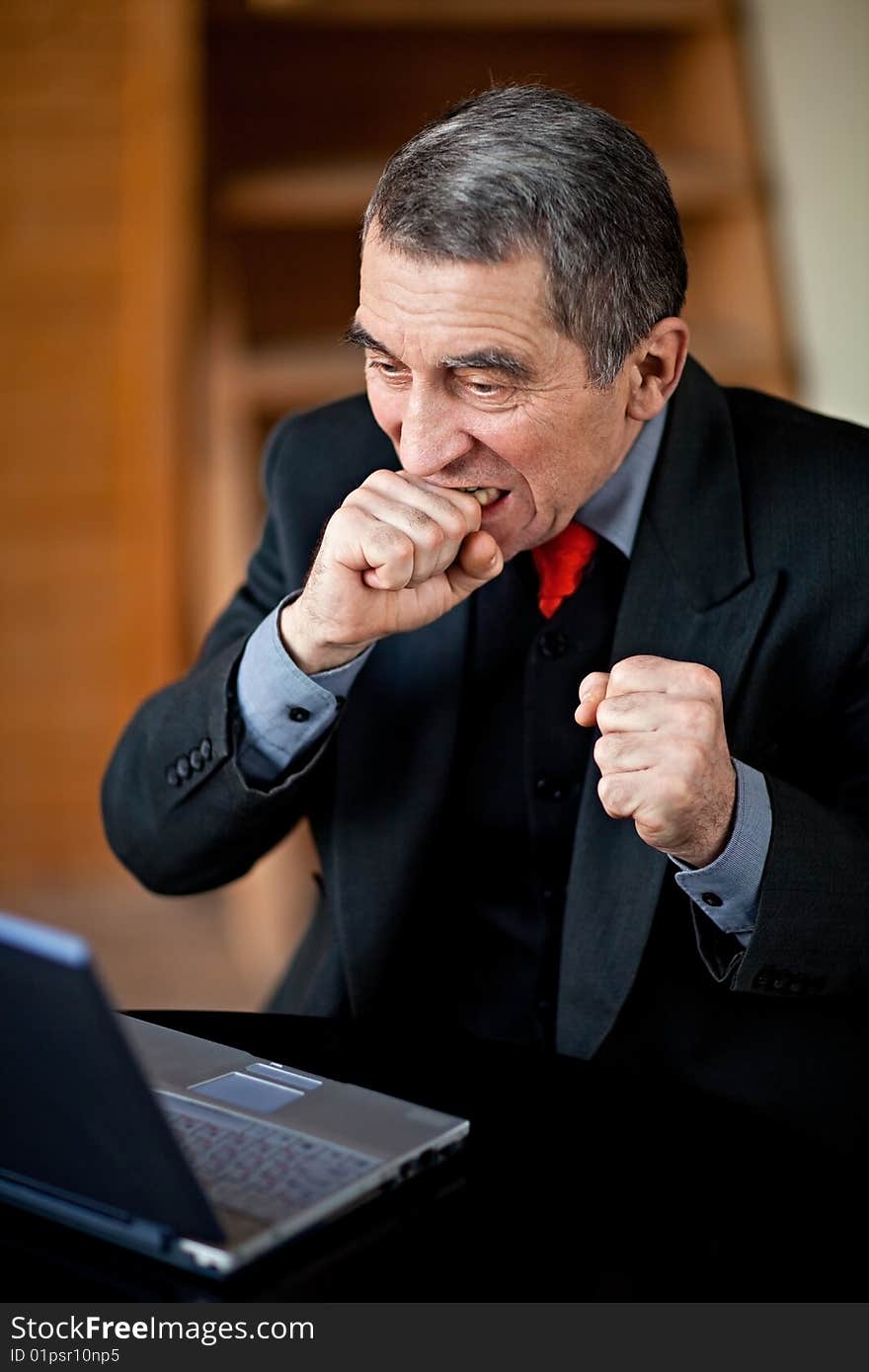 A businessman recoils from his laptop computer in horror. A businessman recoils from his laptop computer in horror.