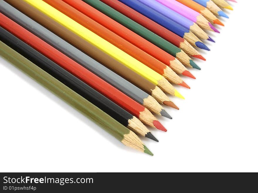 Set of colour pencils, for the drawing, spread out one after another, on the isolated white background