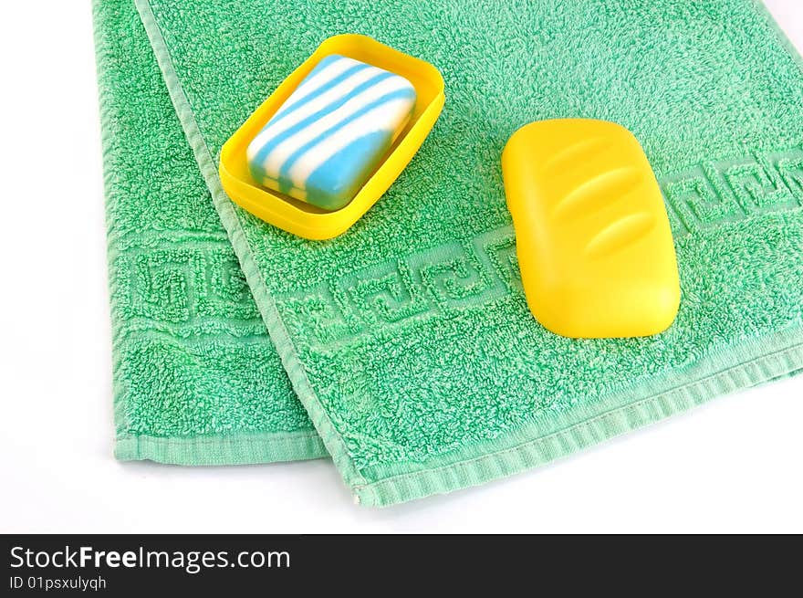 Green towel and soap on a white background