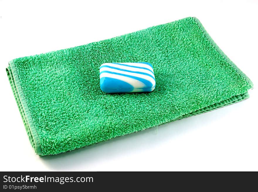 Green towel and soap on a white background