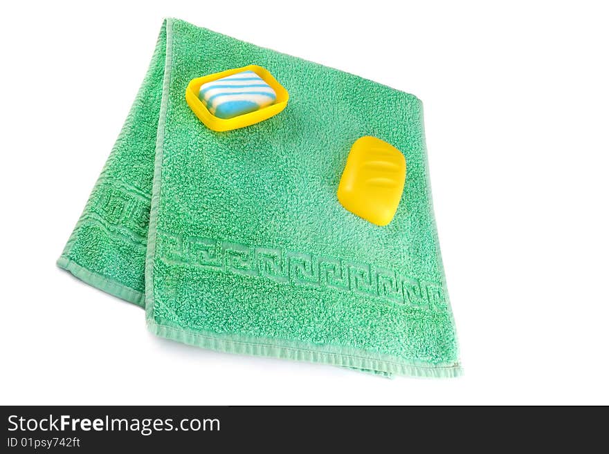 Green towel and soap on a white background