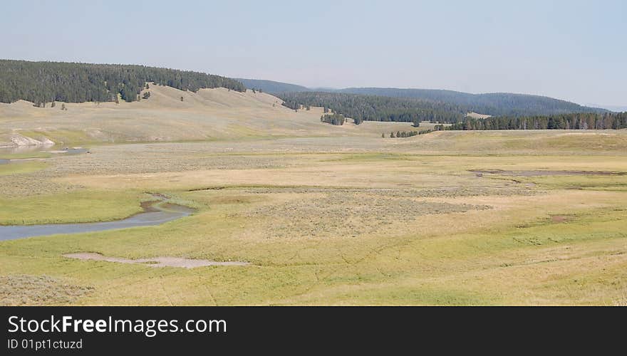 Yellowstone prairie valleys with river meandering through it and animal tracks observable. Yellowstone prairie valleys with river meandering through it and animal tracks observable