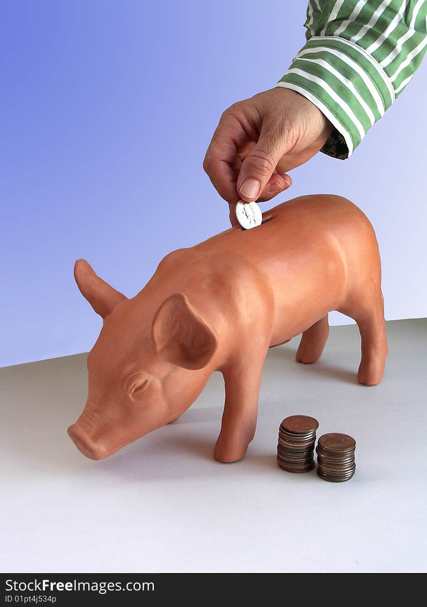 Hand Dropping Coin In Piggy Bank