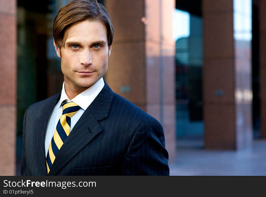 Attractive Businessman in front of a modern office building. Attractive Businessman in front of a modern office building