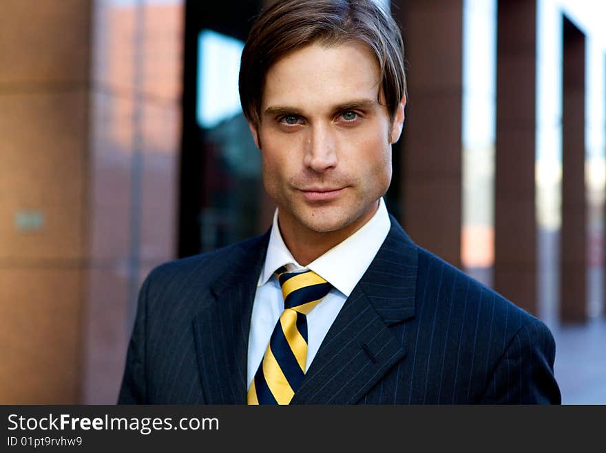 Attractive Businessman in front of a modern office building. Attractive Businessman in front of a modern office building