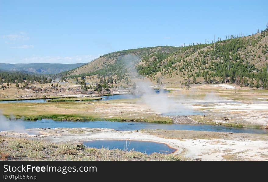 Yellowstone landscape with undulating river and steaming hot springs. Yellowstone landscape with undulating river and steaming hot springs