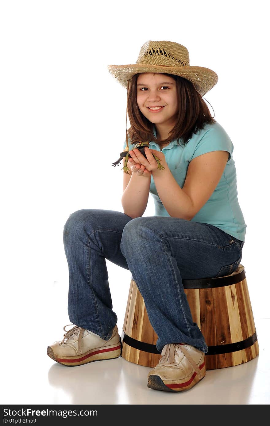 A preteen farm girl happy with the spotted green frog she holds.  Isolated on white. A preteen farm girl happy with the spotted green frog she holds.  Isolated on white.