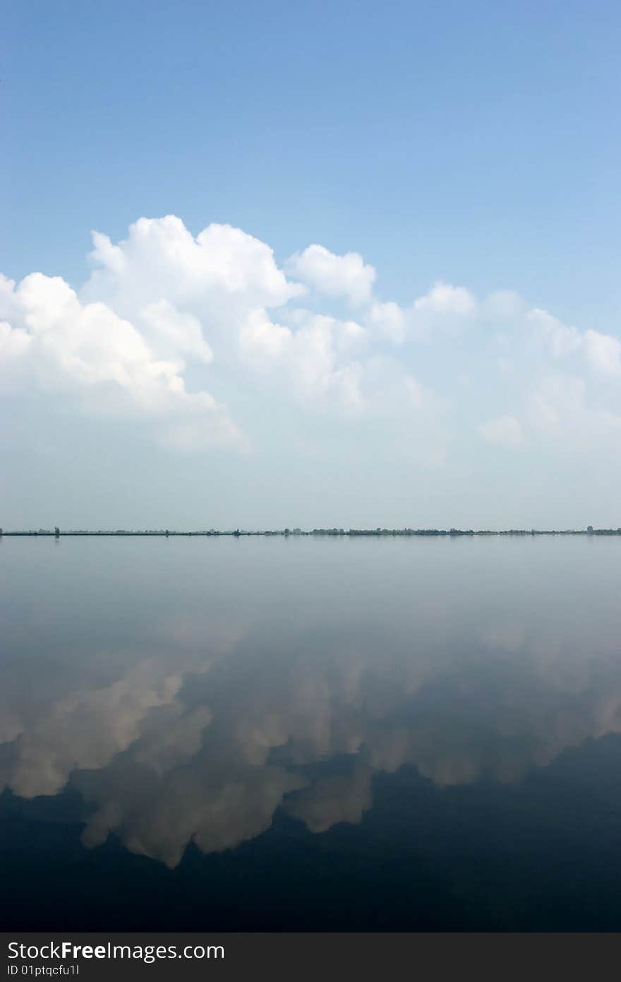 Clouds building up, reflected in quiet water. Clouds building up, reflected in quiet water