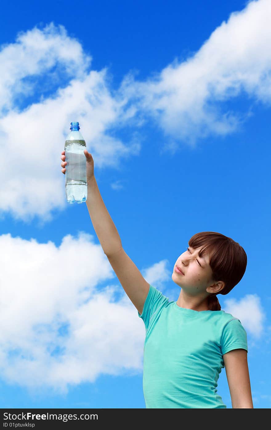 Nice young girl handing bottle of mineral water on background with blue sky. Isolated with clipping path. Nice young girl handing bottle of mineral water on background with blue sky. Isolated with clipping path