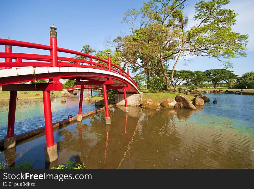 A red bridge in a chinese nature park. A red bridge in a chinese nature park.