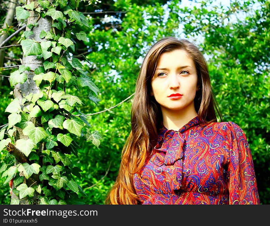 Close up of girls face with trees and ivy background. Vintage. Sad. Close up of girls face with trees and ivy background. Vintage. Sad.