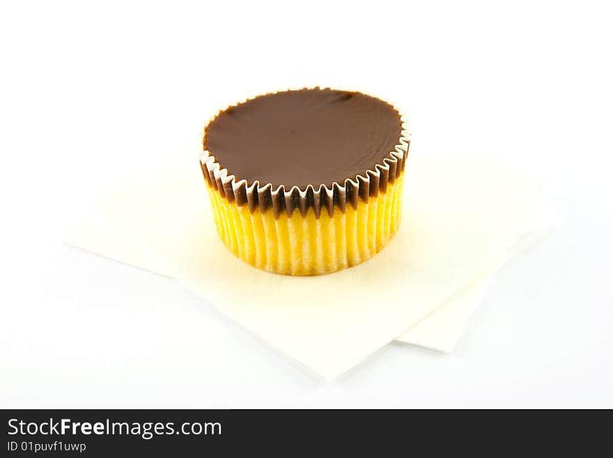 Delicious looking cup cake resting on two white napkins on a plain background