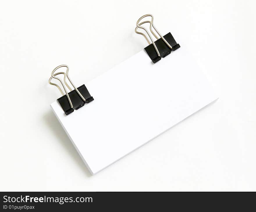 Block of white cards attached with paperclips, isolated over white