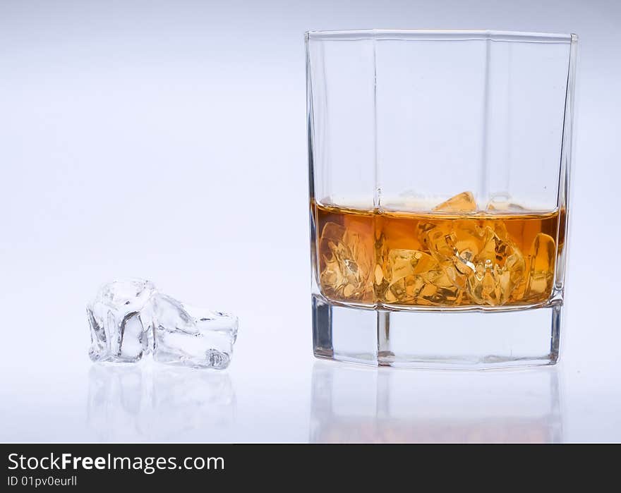 A glass of whisky with ice. A glass of whisky with ice