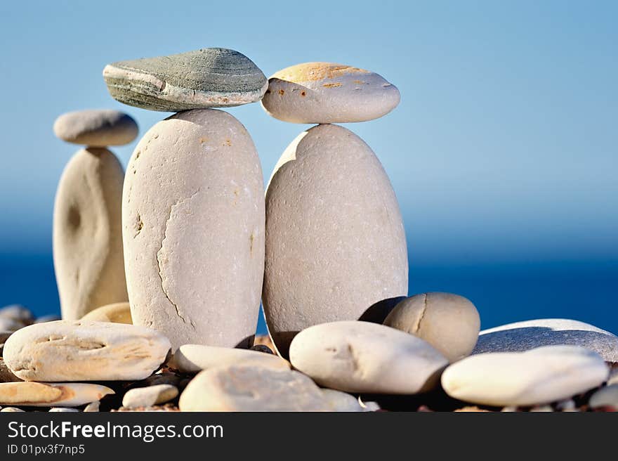 Three small stones balancing on long cobblestones. Three small stones balancing on long cobblestones