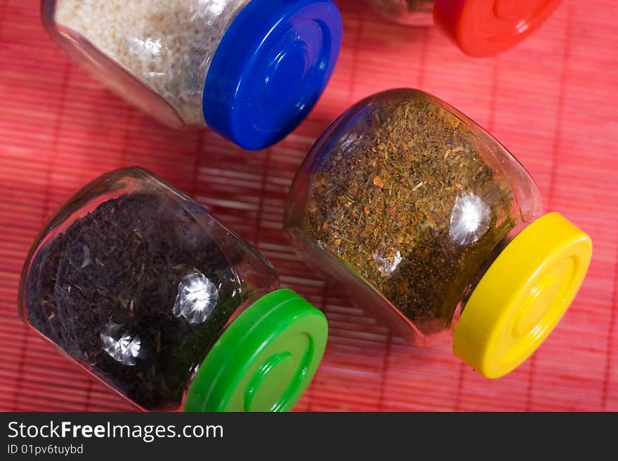 Four glass jars with spices and color covers