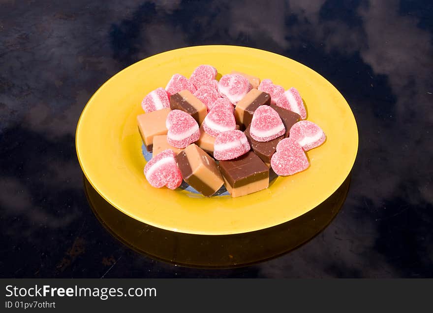 Sweets and marmalade on the yellow plate