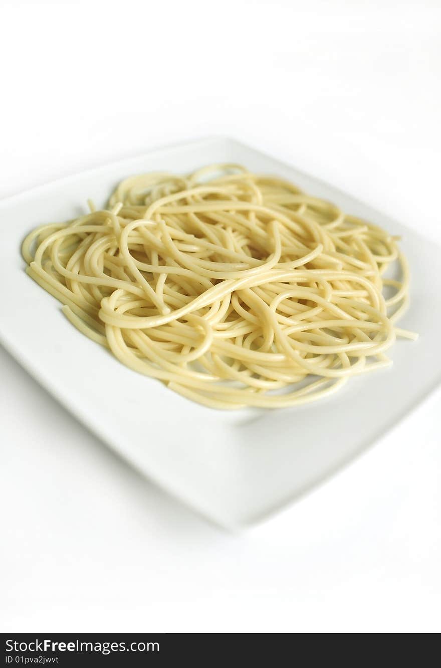 The composition of the macaroni on the plate standing on the white background. The composition of the macaroni on the plate standing on the white background.