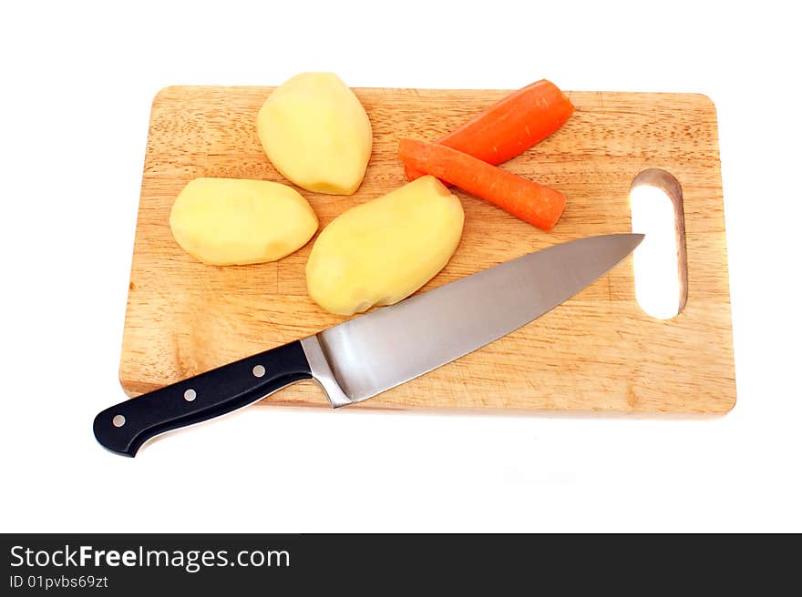 Knife potato and carrots on a wooden board