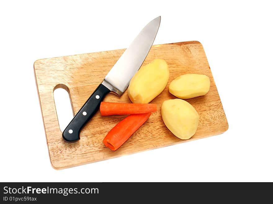 Knife potato and carrots on a wooden board