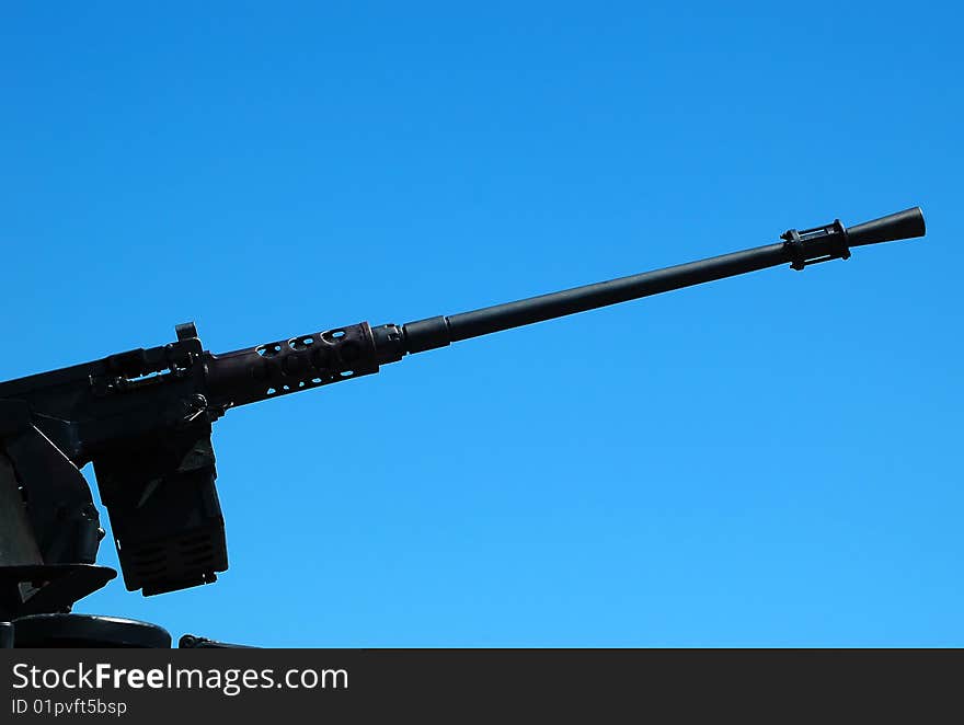 Machine gun on the combat vehicle opposite blue sky. Machine gun on the combat vehicle opposite blue sky