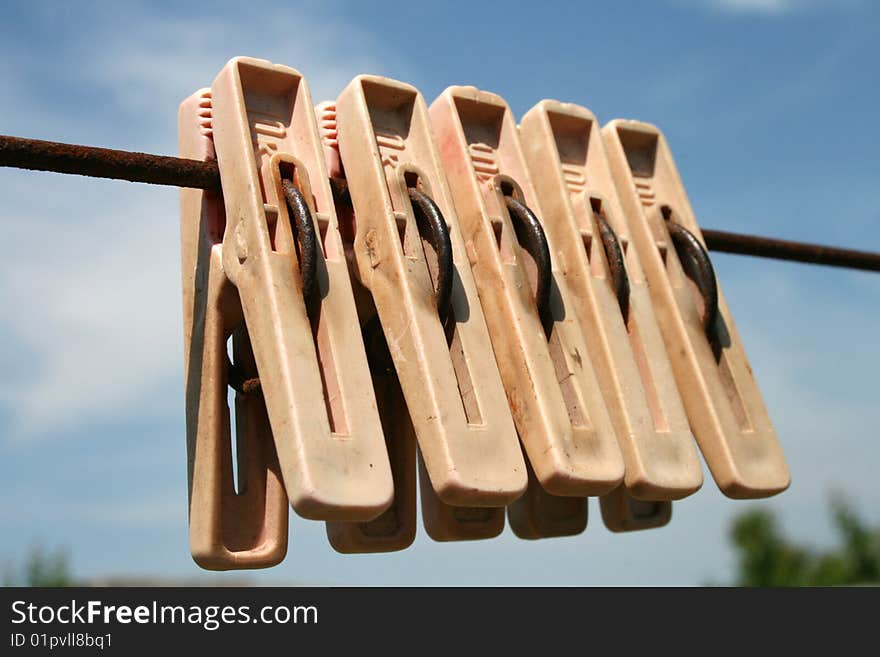 Clothes-pins on a rope on a background sky