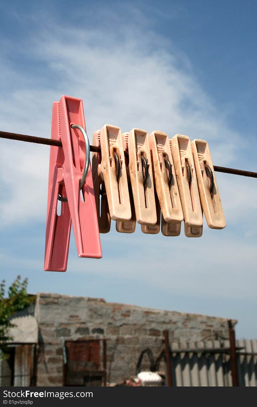 Clothes-pins on a rope on a background sky