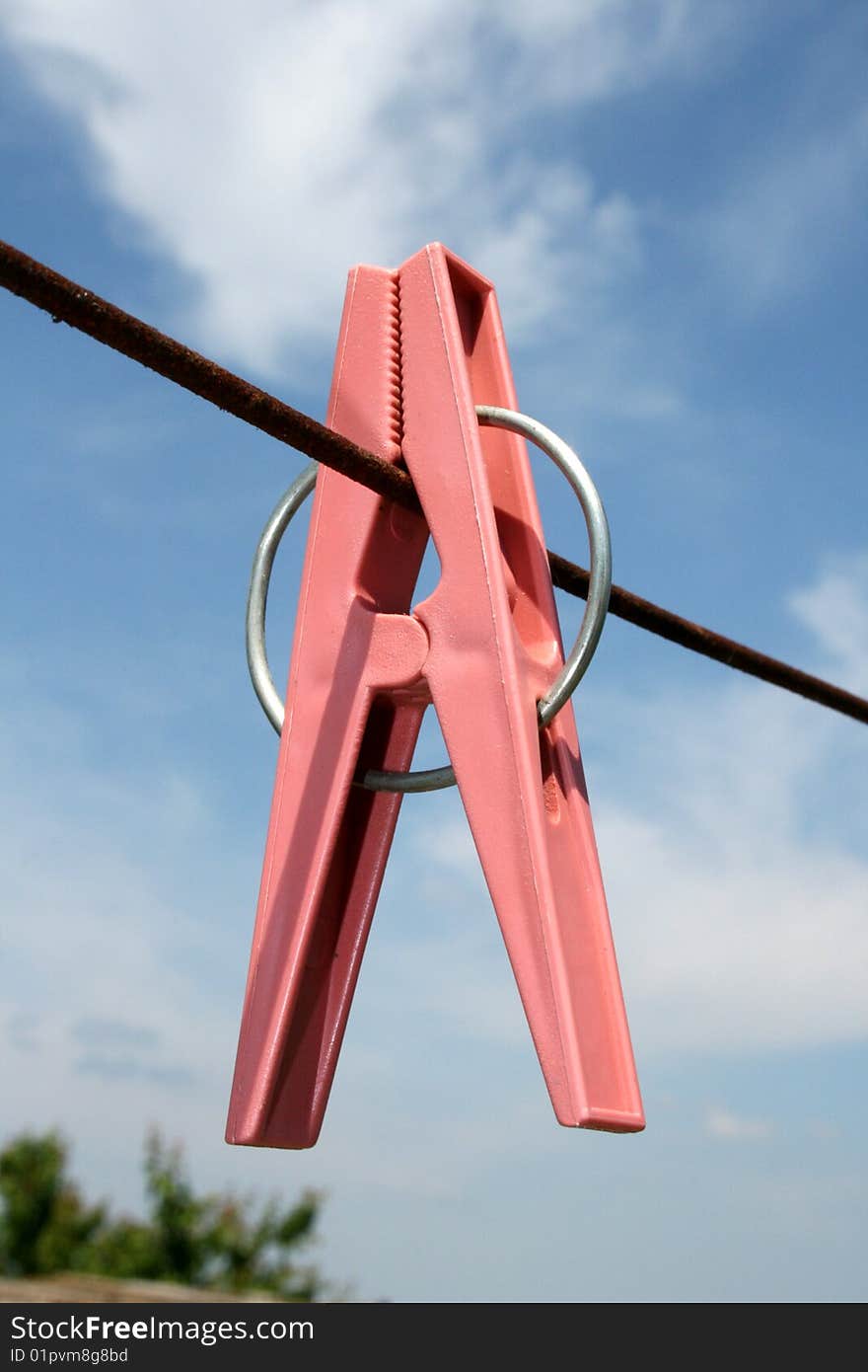 Clothes-pin on a rope on a background sky