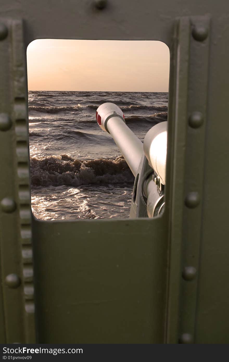 Sight through a gun sight. Against a sea decline.