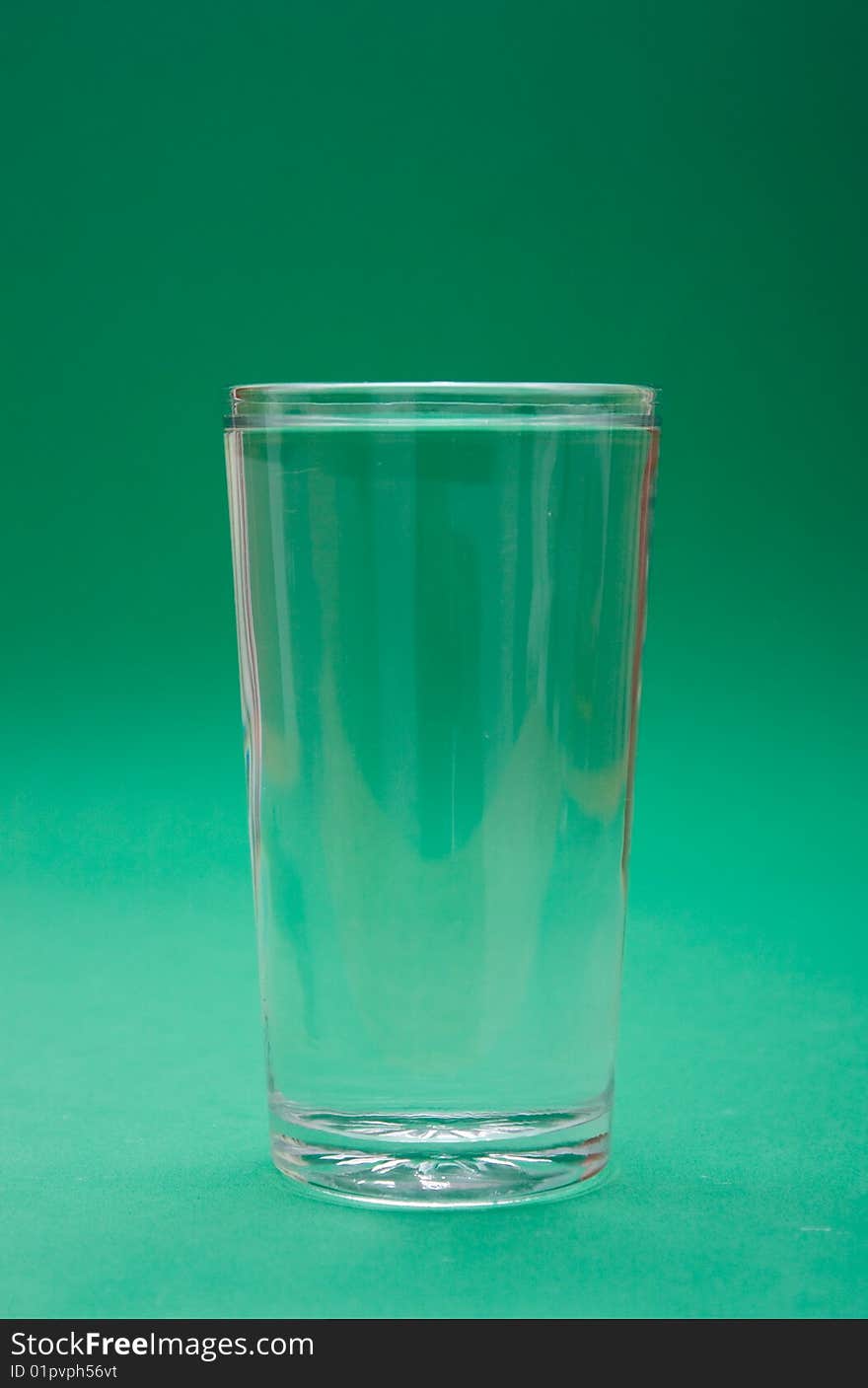 Glass of water on green background. Glass of water on green background